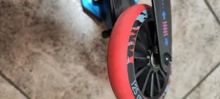 Patinete infantil azul con ruedas rojas