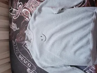 Sudadera gris con cara sonriente