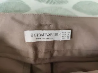 Pantalón beige con cinturón negro