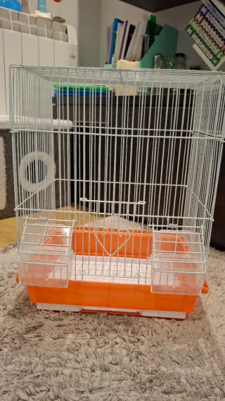 Jaula para loros naranja y blanca