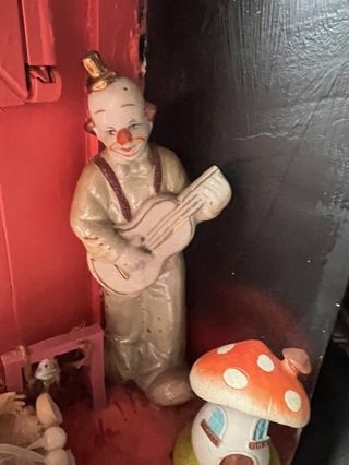 Payaso de cerámica antiguo tocando guitarra