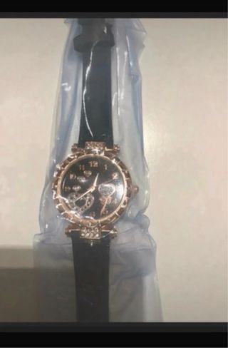 Reloj negro con detalles dorados y pila