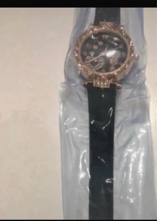 Reloj negro con detalles dorados y pila