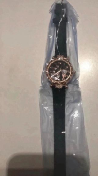 Reloj negro con detalles dorados y pila