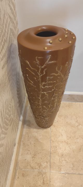 Jarrón decorativo marrón con detalles dorados.