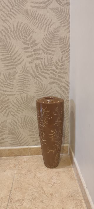 Jarrón decorativo marrón con detalles dorados.