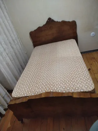 Dormitorio antiguo de madera con somier, colchón..