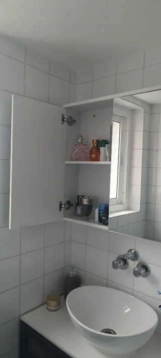 Mueble de baño con espejo y un estante