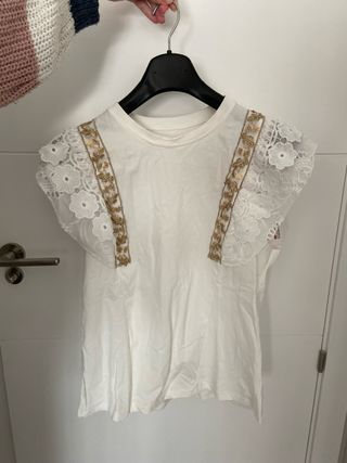 Camiseta blanca con detalles dorados y encaje