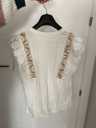Camiseta blanca con detalles dorados y encaje