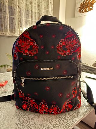 Mochila Desigual negra con estampado rojo.