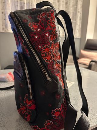 Mochila Desigual negra con estampado rojo.