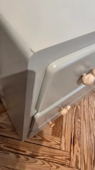 Cómoda de madera con tiradores de madera clara.