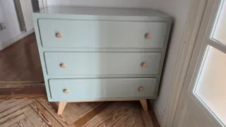 Cómoda de madera con tiradores de madera clara.