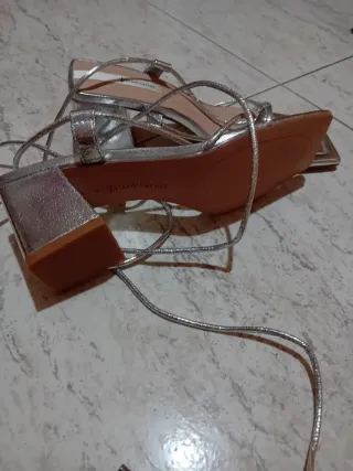 Sandalias Stradivarius plateadas atadas al tobillo