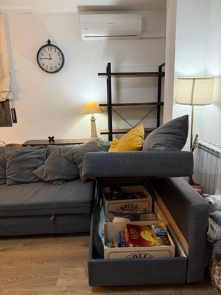 Divano letto grigio con cuscini gialli