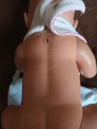Muñeca bebé con babero y manta