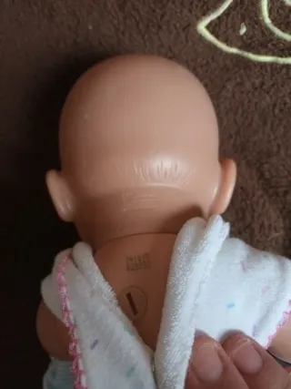 Muñeca bebé con babero y manta