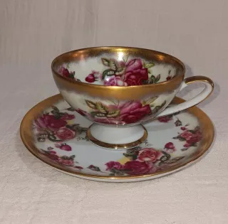 Taza de té y plato con rosas doradas