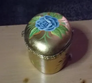 Joyero dorado metálico con flor azul