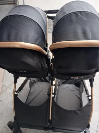 Cochecito gemelar negro y dorado