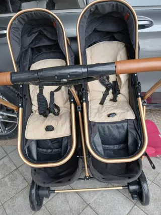 Cochecito gemelar negro y dorado