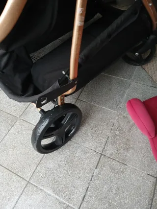 Cochecito gemelar negro y dorado