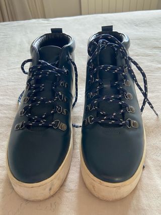 Botas de piel azul marino con suela en blanco.