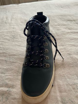 Botas de piel azul marino con suela en blanco.