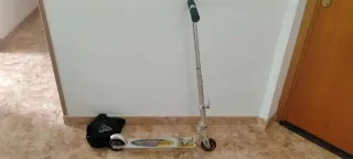 Patinete plegable plateado con mochila