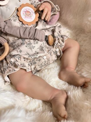 Bebé Reborn realista con traje floral