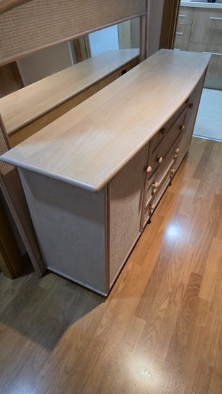 Gran espejo y mueble de madera y ratán.