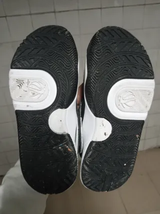 Zapatillas deportivas Nike niño negras y blancas.