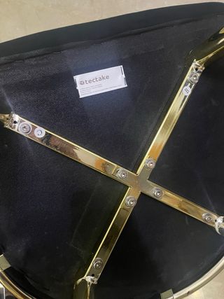 Sillón negro  tectake con patas doradas.