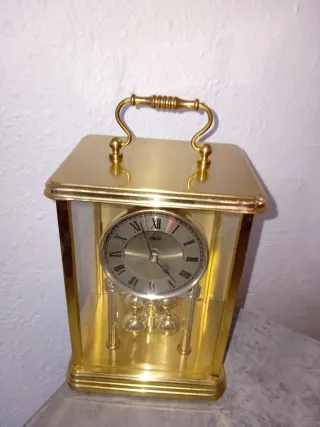 Reloj de sobremesa dorado con péndulo