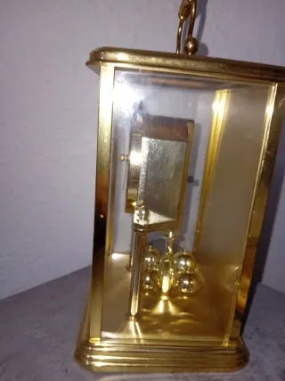 Reloj de sobremesa dorado con péndulo
