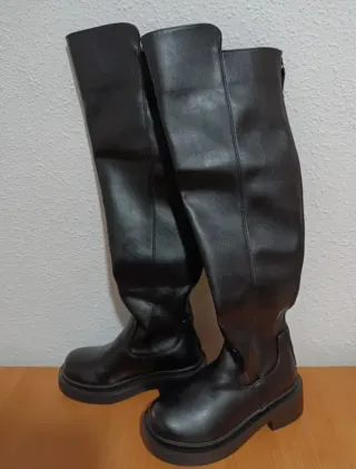 Botas altas negras por encima de la rodilla