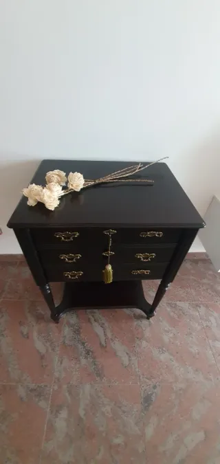 Cajonera de madera negra con detalles dorados