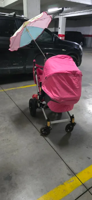 Carrito de bebé rosa con sombrilla