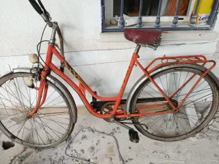 Bicicleta antigua roja para reparar