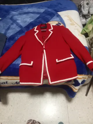 Chaqueta paño en rojo adornos blancos.