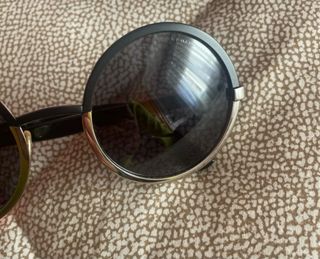 Gafas de sol redondas negras y doradas