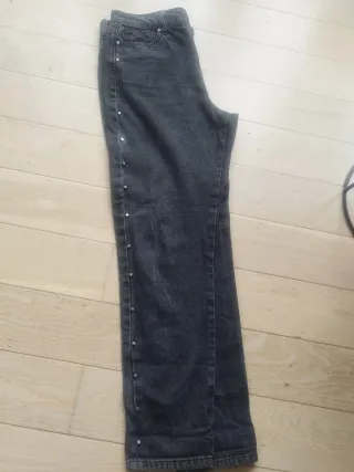 Pantalón negro con tachas plateadas.Green coast.