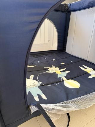 Cuna de viaje azul con diseño de conejos