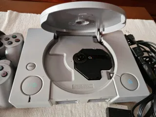 Consola PlayStation 1 Sony Gris con un juego.