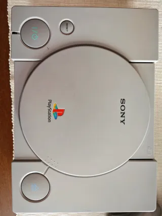 Consola PlayStation 1 Sony Gris con un juego.