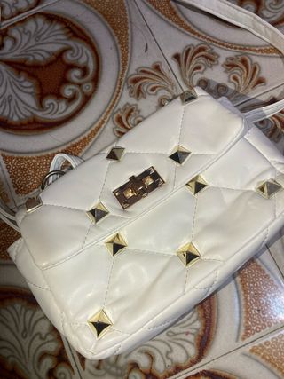 Bolso blanco con tachuelas doradas