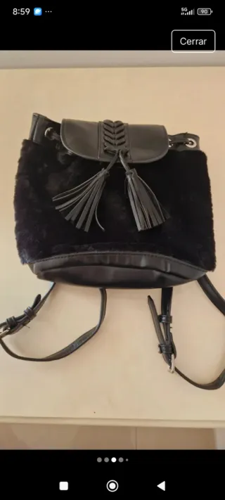 Mochila negra con pelo por fuera.