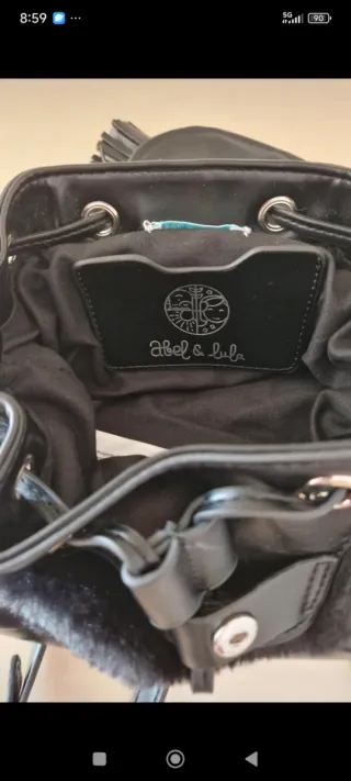 Mochila negra con pelo por fuera.