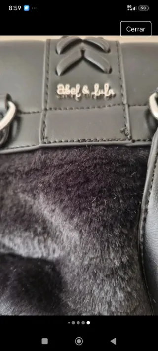 Mochila negra con pelo por fuera.